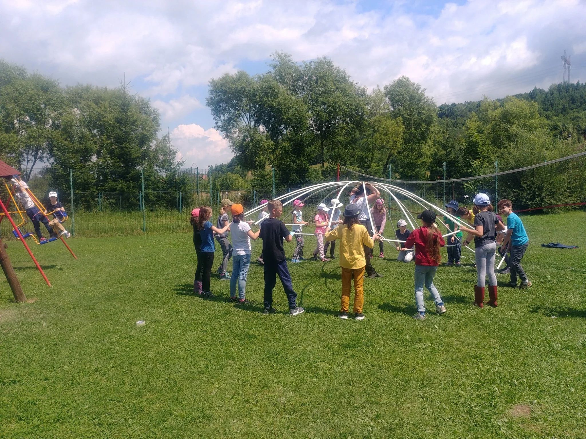 Camp participants assembling the umbrella-inspired dome outdoors